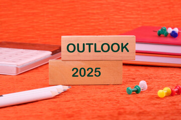 OUTLOOK 2025 on a wooden block in a composition with business accessories
