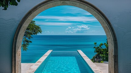 Stunning view of an infinity pool overlooking a tropical ocean, framed by an arched gateway, perfect for luxury travel and resorts.