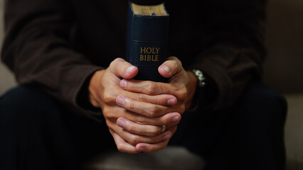 Man praying holding a Holy Bible. believe concept.
