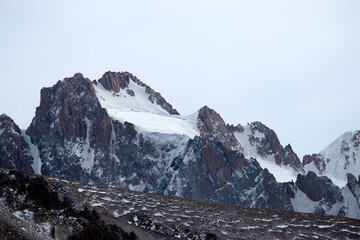 Winter landscape with snowy mountains and clouds. High mountain peaks covered with a layer of snow....