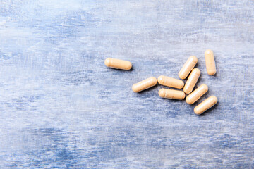 Lutein capsules. Dietary supplement on wooden background. Soft focus. Top view. Close up. Copy...