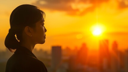 Fototapeta premium Contemplative young businesswoman reflects on work life challenges, gazing at the sunset and evening light against blurred cityscape backdrop