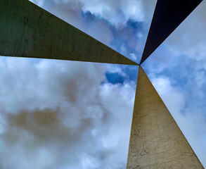 Metal structure seen from below with three bars that meet at the tip.