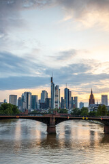 View from a bridge over the River Main to a skyline in the financial district in the background as the sun sets. Twilight in Frankfurt am Main, Hesse Germany