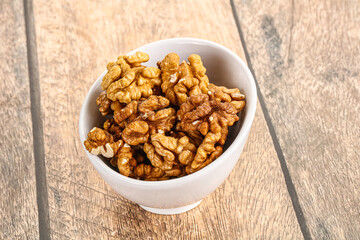 Cracked unshelled walnut in the bowl