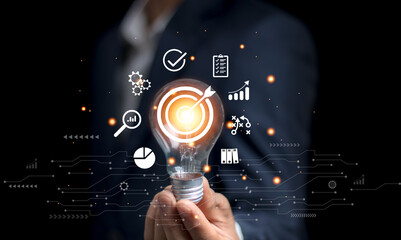 businessman holding a light bulb Business planning concepts, high-performance business processes and workflows and problem solving, quality control and long-term business evaluation tracking.
