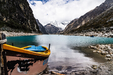 panormaic view of a boat on laguna paron in the snow-covered andes in the Huascarán national park in peru
