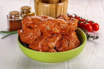 Raw turkey shoulder wing in Indian tandoori marinade