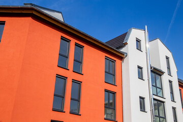 Fototapeta na wymiar Mehrfamilienhaus mit schönem Fassadenanstrich in Weiß und mediterranem Orangeton