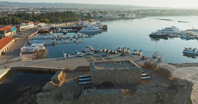 Aerial view of the port and marina in Pathos, Cyprus. Yachts and fishing boats on the pier near the fort castle in the Mediterranean tourist island. High quality 4k footage