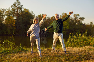 Senior sporty couple doing sport exercising in nature. Happy smiling elderly man and woman in...