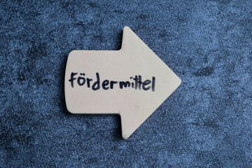 Concept of fordermittel write on sticky notes isolated on Wooden Table.