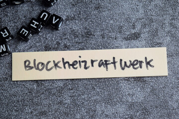 Concept of Blockheizraftwerk write on sticky notes isolated on Wooden Table.