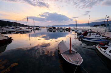 Wooden boat in sea marina at sunset time.