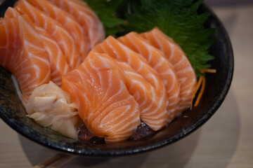 Premium sliced raw salmon or salmon sashimi in fresh Japanese style in black bowl