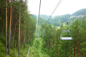 Chairlift to the top of the mountain. Beautiful summer forest landscape. Ski resort
