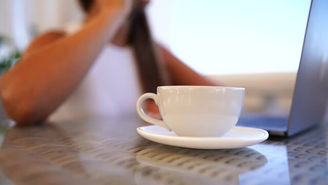 Woman coffee cafe macbook. Woman sitting at a coffee shop with mobile phone drinking coffee and looking away. Caucasian female relaxing at a cafe.