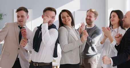 Colleagues in office are dancing dance that symbolizes team spirit and joint achievement of goals. Team of office workers happily dances, enjoying their work and celebrating their success. 4k video.