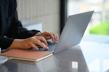 Closeup image of businesswoman hands typing on laptop surfing the internet or online working