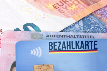 Ein Aufenthaltstitel für einen Flüchtling, Euro Geldscheine und eine Bezahlkarte