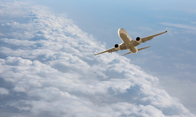 White passenger airplane flying in the sky amazing clouds in the background - Travel by air...