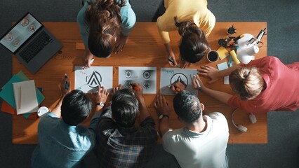 Top view of business team put graphic logo on meeting table with laptop and paper and start to...