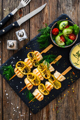 Poultry meat skewers - grilled meat with lime slices on wooden background
