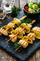 Poultry meat skewers - grilled meat with lime slices on wooden background
