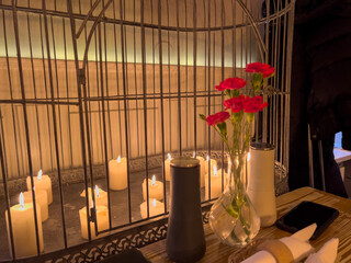 Carnation flowers in a vase and candles decor on a table in a restaurant 