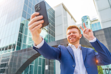 Businessman gesturing success while taking selfie outdoors