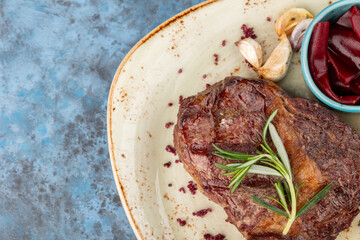 grilled beef steaks with spices on blue background