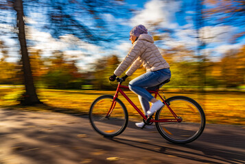 Motion Blur. Woman riding bicycle in city park
