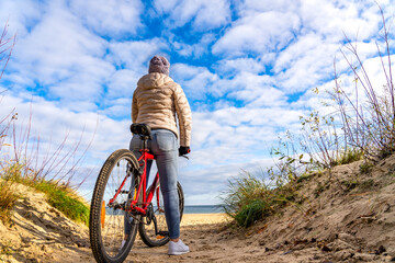 Mid-adult woman riding bicycle at seaside
