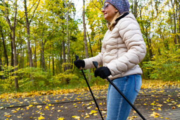 Mid-adult woman exercising Nordic walking in city park
