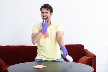 Funny man cleaning home. Man feeling bad after exhausting housekeeping	