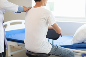 Obraz premium man was admitted for treatment of muscle pain in back of his shoulder due to working hard and causing muscle inflammation. doctor is treating man muscle pain in his back and shoulders due to overwork.