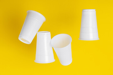 Disposable plastic cups closeup on a yellow background