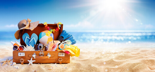 Summer Beach Preparation - Suitcase And Accessories With Sand And Defocused Glittering On Sea - Travel and Departure Concepts