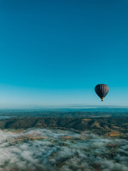 Obraz premium Black hot-air balloon flying over the mountain, awesome landscape view, Melbourne, Australia, Yarra Valley. 