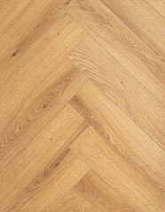  Geringbone pattern laminate in light brown with shades of beige, imitating the texture of natural wood. 
