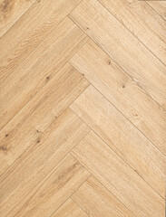 Geringbone pattern laminate in light brown with shades of beige, imitating the texture of natural...
