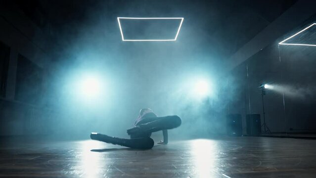 Woman performing modern dance on high heels. Graceful female dancing in studio with smoke and spotlight. Attractive talented woman dancing in studio. 4K, UHD