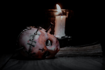 a bloody doll head and a burning candle, a scary doll head full of blood