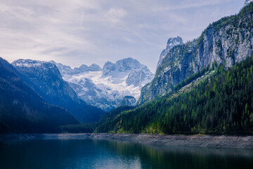 A magical morning atmosphere at a lake that is surrounded by alpine mountains.