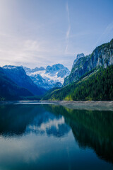A magical morning atmosphere at a lake that is surrounded by alpine mountains.