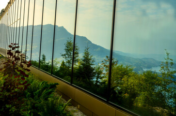 Hotel Five Stars B&uuml;rgenstock with Glass Wall with reflection over Lake Lucerne and Mountain in Sunny Day in B&uuml;rgenstock, Nidwalden, Switzerland.