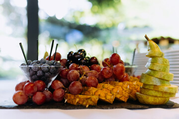 fruit platter on a plate for a festive table. berries and chopped fruits is a delicious and healthy...