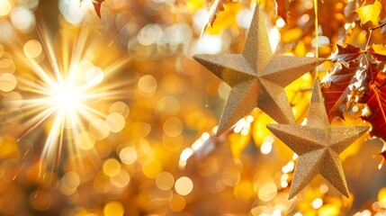   Three golden stars suspend from a tree, surrounded by autumn leaves in the foreground Behind, a sunburst illuminates the backdrop