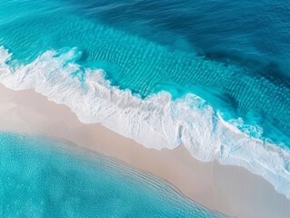 Fototapeta premium Aerial View of Crisp White Waves Crashing onto a Sandy Beach with Clear Turquoise Water 