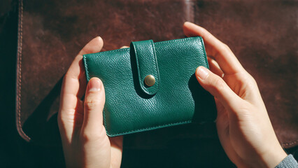 Green wallet in hands of man, close-up